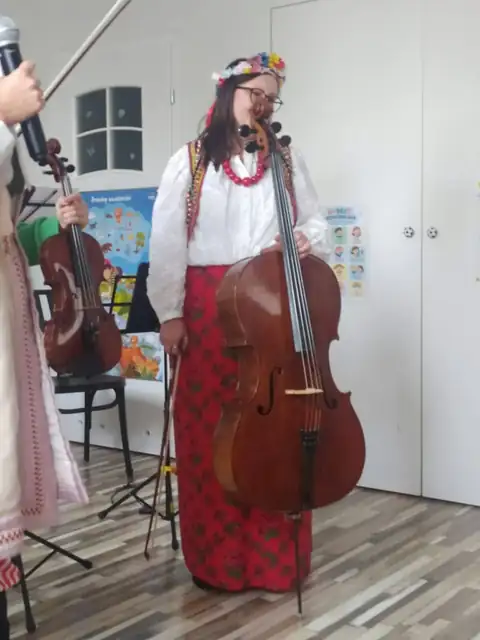 Muzyczka z wiolonczelą w ludowym stroju