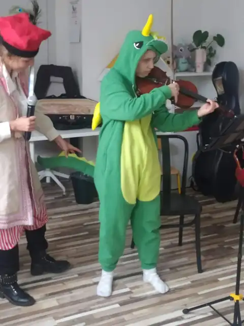 Smok Wawelski grający na skrzypcach