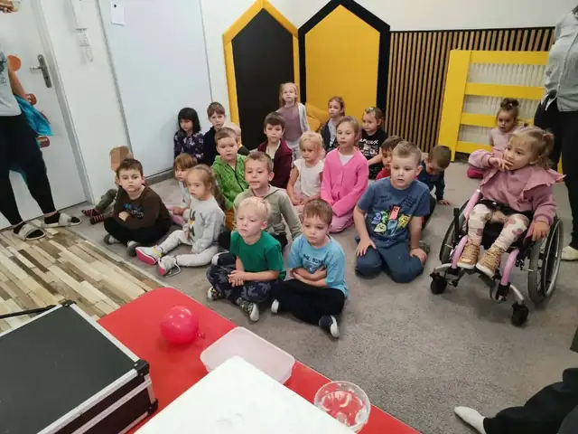 Przedszkolaki oglądają pokaz sztuczek magicznych