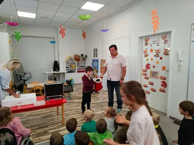 Przedszkolaki oglądają pokaz sztuczek magicznych