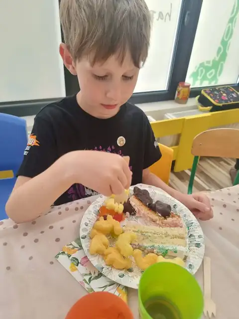 Przedszkolaki jedzą urodzinowy tort