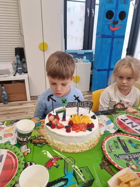 Solenizant przy urodzinowym torcie z owocami