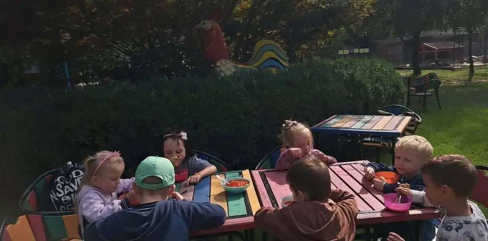 Posiłek przedszkolaków przy stolikach